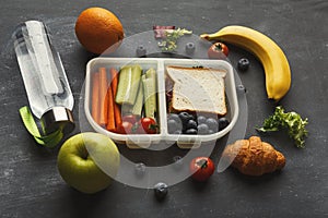 Lunch box with healthy food on black table background