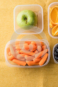 Lunch box with healthy snacks. Plastic container with fruits and vegetables closeup
