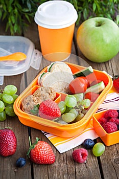 Lunch box with sandwich and fruits