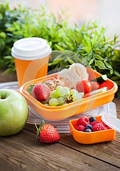 Lunch box with sandwich and fruits