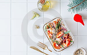 Lunch box with warm salad with grilled chicken, spicy chickpeas, tomato and arugula