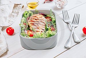 Lunch boxes with chicken and salad, ready to go for work or school. Meal preparation or dieting concept