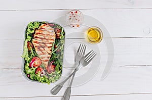 Lunch boxes with chicken and salad, ready to go for work or school. Meal preparation or dieting concept