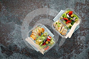 Lunch boxes with grilled chicken breast and pasta salad with fresh vegetables