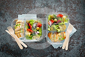 Lunch boxes with grilled chicken breast and pasta salad with fresh vegetables. Top view