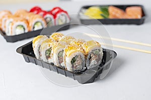 Lunch boxes with sushi set. Assorted fresh rolls philadelphia, california, sashimi on light background. Tasty vegetarian
