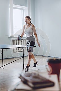 Lunch break activities concept. Office games during Lunch break. Attractive young Business woman playing ping pong, table tennis