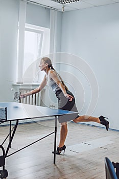 Lunch break activities concept. Office games during Lunch break. Attractive young Business woman playing ping pong, table tennis