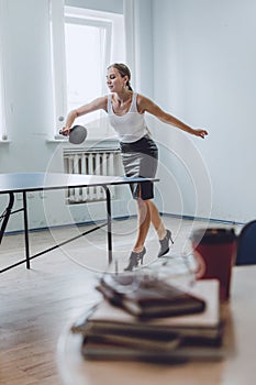 Lunch break activities concept. Office games during Lunch break. Attractive young Business woman playing ping pong, table tennis