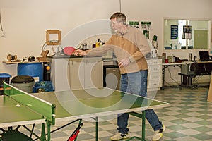 Lunch break at work. Senior citizen plays ping pong very emotionally.