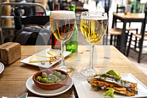 Lunch with cold beer in Spanish outdoor cafe, different tapas, fish, green olives and Spanish cheese manchego with nuts, Malaga,