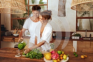 Lunch. Couple At Kitchen On Romantic Weekend. Beautiful Woman Holding Glass While Happy Man Pours Smoothie.