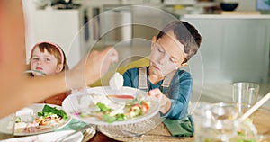 Lunch, dining room and mother dish her child healthy food for health, wellness and nutrition. Happy, hungry and young