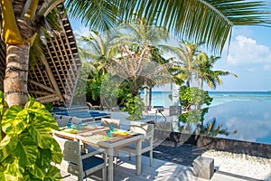 Lunch dining set up white chairs and table near swimming pool at the tropical outdoor restaurant at island luxury resort