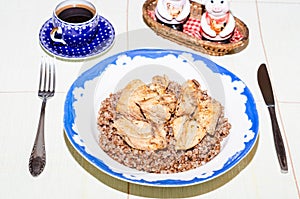 Lunch or dinner of a bachelor. Plate with buckwheat and chicken meat on a round table covered with a tablecloth. meager lonely man