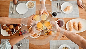 Lunch, hands and people toast with orange juice, beverage or glass drinks at lunch, brunch or food meal. Fruit liquid