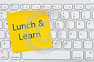 Lunch and Learn message on yellow sticky note on a gray keyboard