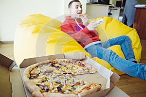 Lunch in office - man sitting with feet on the table, suffering from overeating