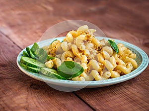 Lunch with pasta with minced meat and mugs of fresh orurtsa on a light green plate