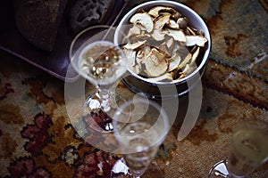 Lunch Provencal style still life with champagne in glasses on table, flower pattern, bread, apples, daylight.