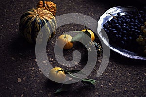 Lunch Provencal style still life on wooden table, flower pattern, seasonal vegetables, wine grapes, pumpkin, daylight.