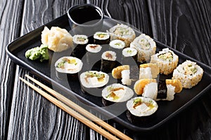 Lunch set Japanese sushi rolls with seafood, vegetables, tofu and tamago closeup on a plate. horizontal