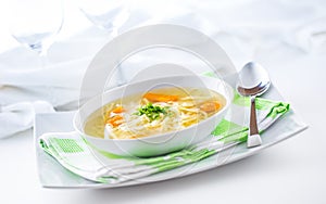 Lunch setting table with chicken or beef soup with noodles carrot and herbs