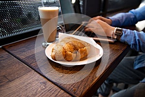 Lunch time concept. Delicate croissant and delicious latte. Close up view of food. Cafe on background. Cozy coffeehouse