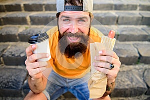 Lunch time concept. Hipster enjoy hot dog and drink paper cup beverage. Fast food for lunch common idea. Man bearded