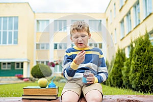 Lunch time at school.A boy in the schoolyard eats fresh fruits and vegetables. change of outdoors. Sour cherries, baby wrinkled