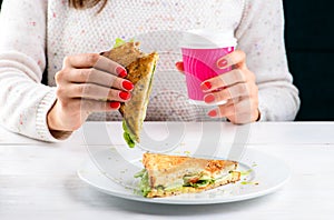 Lunch time Unidentified woman eating BLT sandwich