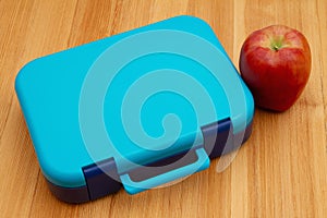 Lunchbox with apple for health school lunch on wood desk photo