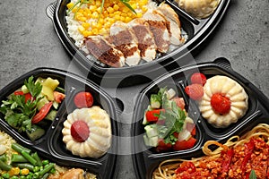 Lunchboxes with different meals on grey table. Healthy food delivery