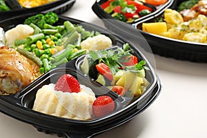 Lunchboxes with different meals on white, closeup. Healthy food delivery