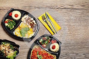 Lunchboxes with different meals on wooden table. Healthy food delivery