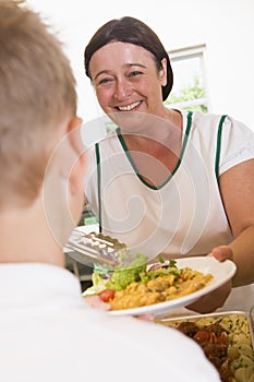 Lunchlady serving plate of lunch in a school