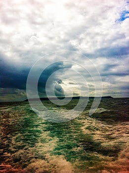 Lundy Island with a storm brewing, from the back of a boat.