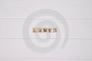 Lunes week day name on white wooden background photo