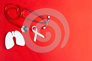 Lung cancer awareness red background with white ribbon and stethoscope