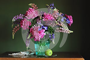 Lupins and peonies. still life with garden flowers and Apple