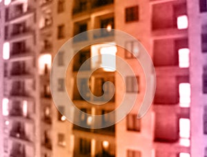 lurred office building with illuminated facade exterior at night. Blurry modern business building with bokeh light and defocused