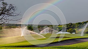 A lush golf course, with a rainbow in the background, in South Africa.