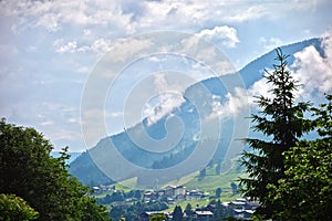 Lush green alpine peak under a blue cloudy sky in Saalbach, Austria