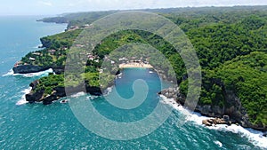 Lush green tropical forest on cliffs and Gesing Beach aerial panorama, Indonesia