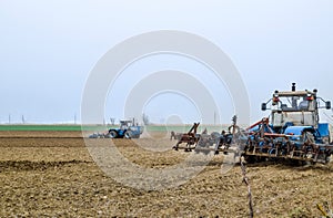 Lush and loosen the soil on the field before sowing. The tractor plows a field with a