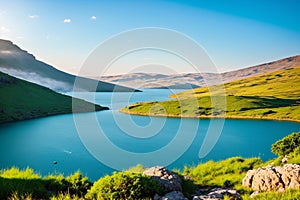 lush spring vegetation on the lake, grass, rocks, blue water, mountains, haze, cloudy sky, evening. Israel,