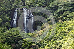 Lush tropical jungle landscape with tall waterfall on the island