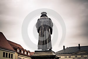 Luther statue in Eisleben, his birth and death place,  Germany. Evangelical lutheran reformer holding Bible and refusing papal