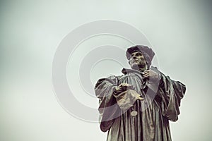 Luther statue in Eisleben, his birth and death place,  Germany. Evangelical lutheran reformer holding Bible and refusing papal