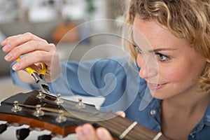 luthier apprentice cleans concert guitar with care